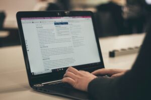 man writing on computer